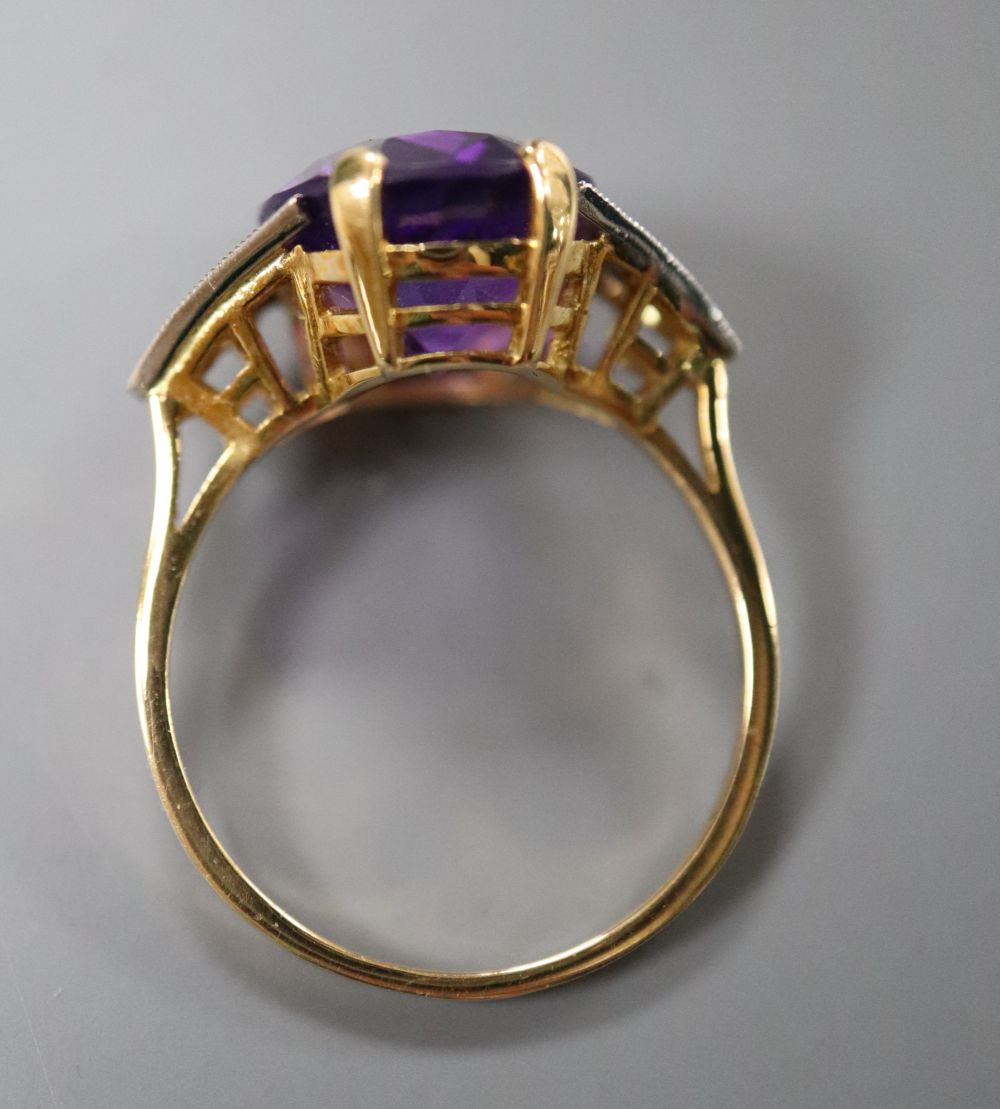An Art Deco style yellow metal, amethyst and diamond seven-stone ring, the oval amethyst claw-set, size N, gross 3.7 grams.